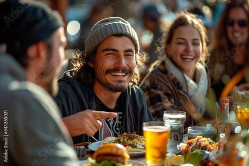 Group of friends enjoying lunch at an outdoor cafe, laughing, eating tacos, and drinking beer together