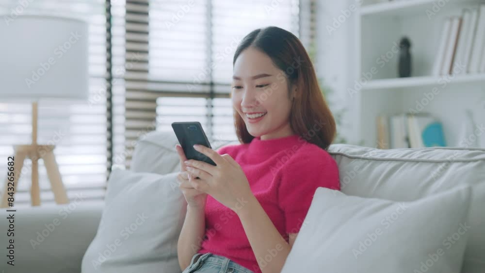 Happy young asian woman relax on comfortable couch at home texting messaging on smartphone, smiling girl use cellphone chatting, online shopping at home, video call communication Happy young asian woman relax on comfortable couch at home texting messaging on smartphone, smiling girl use cellphone chatting, online shopping at home, video call communication