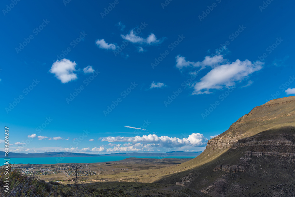 A beautiful blue sky with a few clouds and a mountain in the background