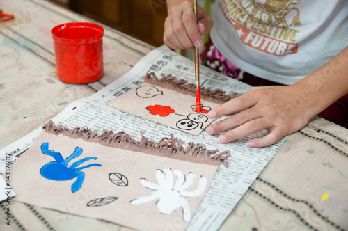 絵画教室でカラフルな絵の具で絵を描く小学生の子ども