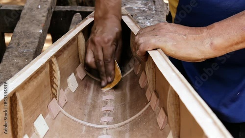 Harp Maker Smoothing Wood while making a Harp in his Workshop. Close Up. 4K Resolution. photo