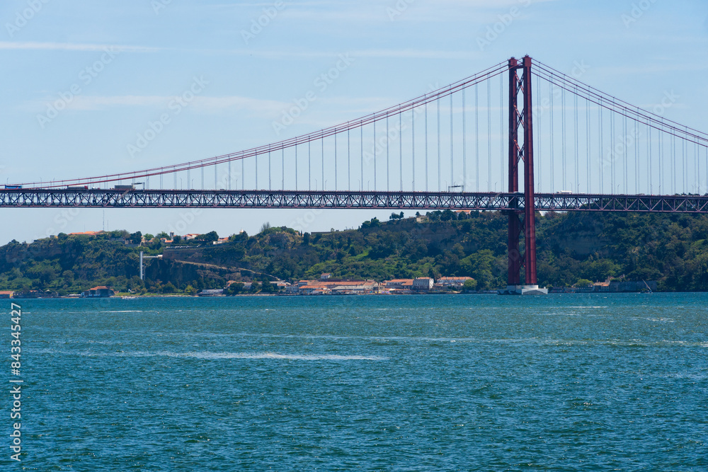 Fototapeta premium The 25th April Bridge, Ponte 25 de Abril in Portuguese, the longest suspension bridge in Europe. Connecting the city of Lisbon, capital of Portugal, to the municipality of Almada over the Tagus River.