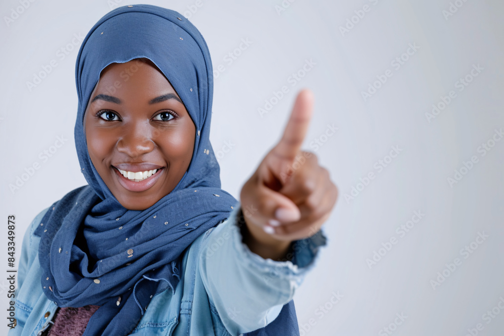 a woman wearing a head scarf pointing her finger a woman wearing a head scarf pointing her finger