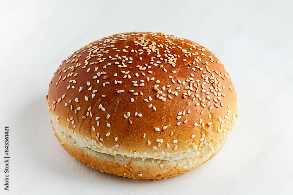Top view of a golden brown hamburger bun sprinkled with sesame seeds, isolated on white Top view of a golden brown hamburger bun sprinkled with sesame seeds, isolated on white