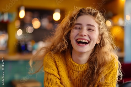 Wallpaper Mural Joyful Young Woman Laughing in a Cozy Cafe Setting with Natural Lighting and Casual Attire Torontodigital.ca