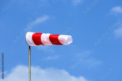 Fotografi Windsock in red and white colors against a blue sky