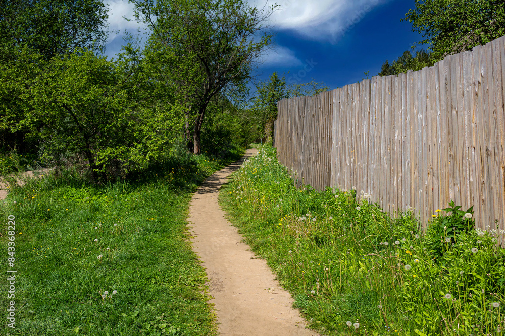 A path in the village along the fence. A path in the village along the fence.