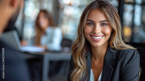 Wallpaper Mural A woman smiles warmly at someone off camera, while sitting at her desk in a modern office Torontodigital.ca