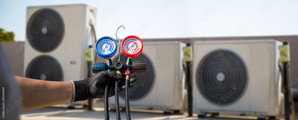 Technician use manifold gauge check and filling refrigerant vacuum pump evacuates industry air conditioning HAVC system maintenance or chiller and air conditioner cleaning filter service. Technician use manifold gauge check and filling refrigerant vacuum pump evacuates industry air conditioning HAVC system maintenance or chiller and air conditioner cleaning filter service.