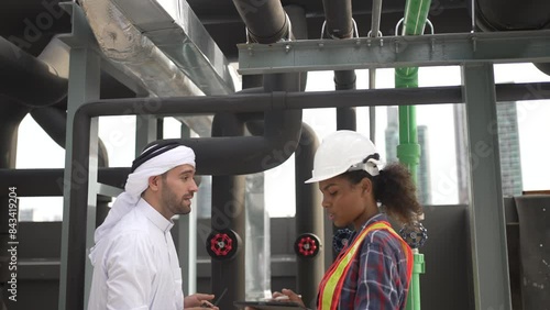 Middle eastern man and African woman are working together on rooftop.