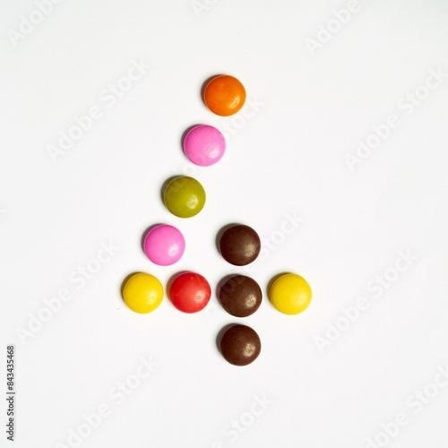 Colored chocolate coated candy alphabet on white background. 4 photo