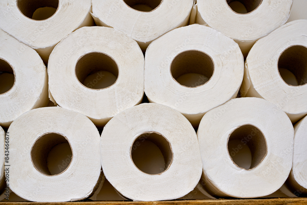 Pile of white toilet papers on a shelf in a white bathroom. Pile of white toilet papers on a shelf in a white bathroom.