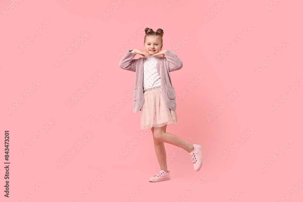 Cute little girl dancing on pink background Cute little girl dancing on pink background