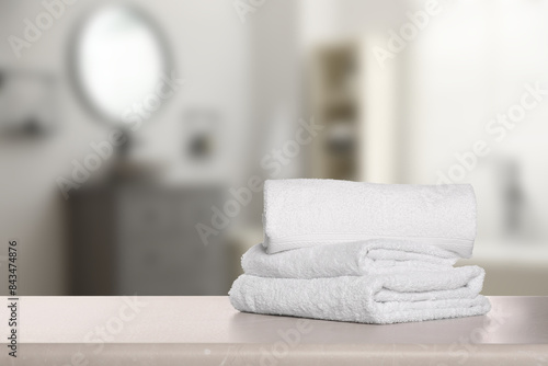Folded fresh towels on table in bathroom. Space for text