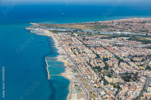 Aerial view of the city of Fiumicino near Rome airport, with historic ancient site of Ostia Antica Roman ruin excavations and the river Tiber flowing out to the Mediterranean Sea in summer sunshine photo