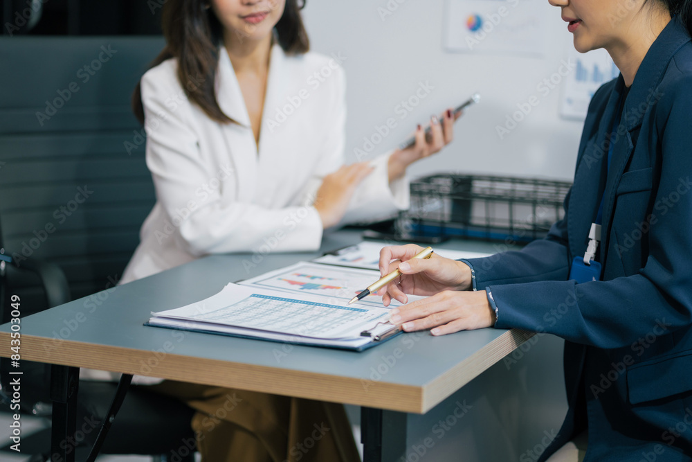 Businesswoman team or financial data analysts working with tablets and laptop computers and data graphs together. Plan to analyzing projects in the office. Businesswoman team or financial data analysts working with tablets and laptop computers and data graphs together. Plan to analyzing projects in the office.