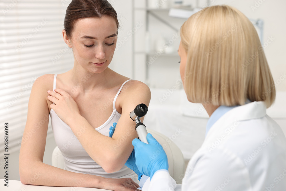 Dermatologist with dermatoscope examining patient in clinic Dermatologist with dermatoscope examining patient in clinic