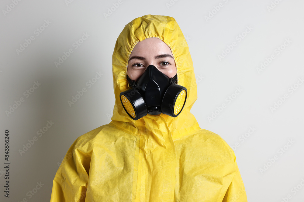 Worker in respirator and protective suit on grey background Worker in respirator and protective suit on grey background