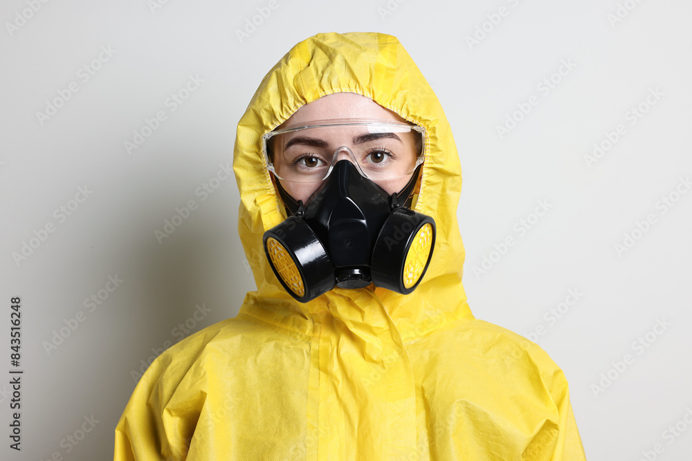 Worker in respirator, protective suit and glasses on grey background Worker in respirator, protective suit and glasses on grey background