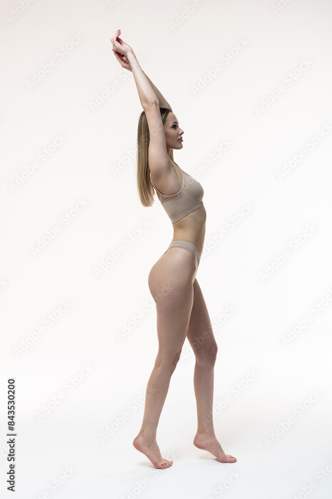 © F8  \ Suport Ukraine - Portrait of woman with slim fit figure in gray inner wear posing on grey studio background.