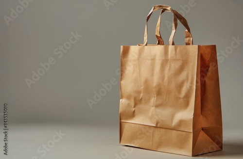 Brown Paper Shopping Bag With Rope Handles on Grey Background