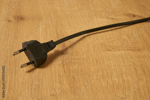 Black electrical euro plug on a table