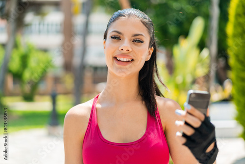 Young pretty sport woman at outdoors using mobile phone Free Download Young pretty sport woman at outdoors using mobile phone - GFXLoad