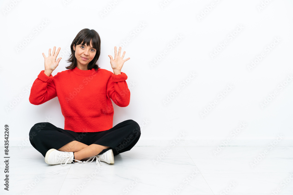 Young mixed race woman sitting on the floor isolated on white background counting ten with fingers Young mixed race woman sitting on the floor isolated on white background counting ten with fingers