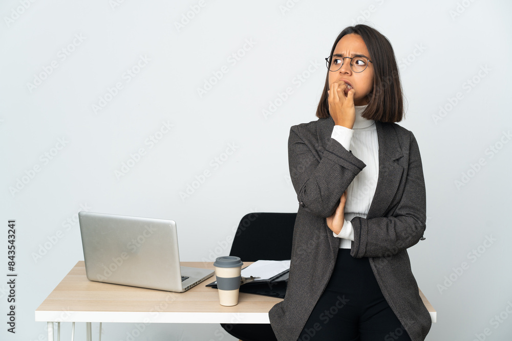 Young latin business woman working in a office isolated on white background is a little bit nervous Young latin business woman working in a office isolated on white background is a little bit nervous