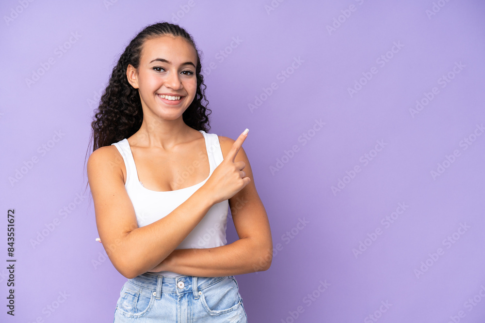 Young woman isolated on purple background pointing to the side to present a product Young woman isolated on purple background pointing to the side to present a product
