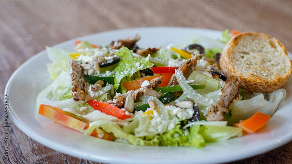 Close up of vegetable salad with beef olives, cheese and slice of bread on a white plate Close up of vegetable salad with beef olives, cheese and slice of bread on a white plate