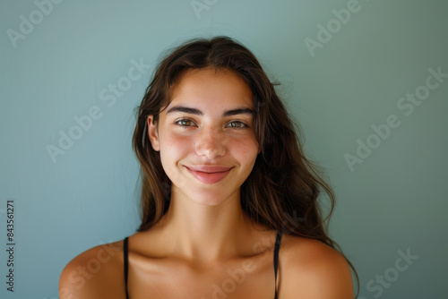 A close up portrait of a young woman with a subtle smile