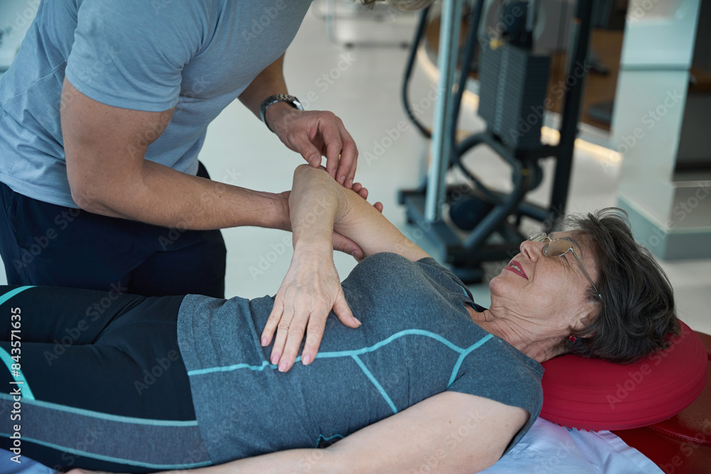 Physiotherapist working on female patients elbow joint Physiotherapist working on female patients elbow joint