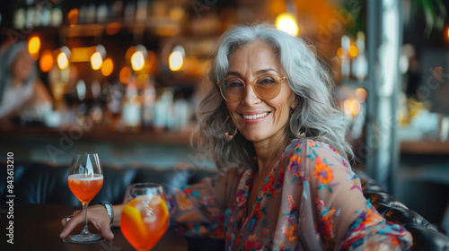 Beautiful elderly woman with gray hair and glasses in a bar.