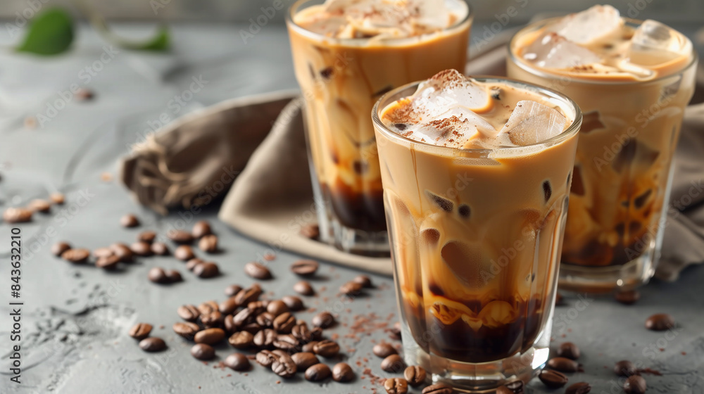 Ice coffee in a tall glass with cream poured over, ice cubes and beans. Cold brew. Ice cappuccino. Ice coffee in a tall glass with cream poured over, ice cubes and beans. Cold brew. Ice cappuccino.