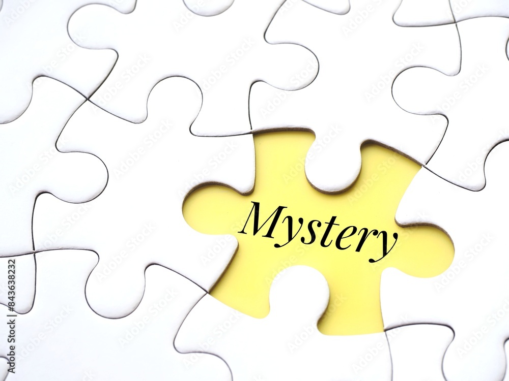 Fototapeta premium A white puzzle with a single yellow gap with the word 'mystery' written inside. Mystery or enigma concept