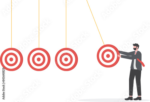 business target achievement as a milestone to achieve the next target, businessman pulling target board with bullseye arrow as a pendulum for milestone the next target

