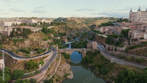 Plano aéreo con dron sobre la ciudad histórica medieval de Toledo, Castilla La Mancha, España. Río tajo junto al Puente de Alcántara y el Alcázar.