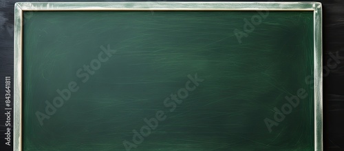 A hand holding chalk on a green chalkboard with plenty of copy space for writing and drawing