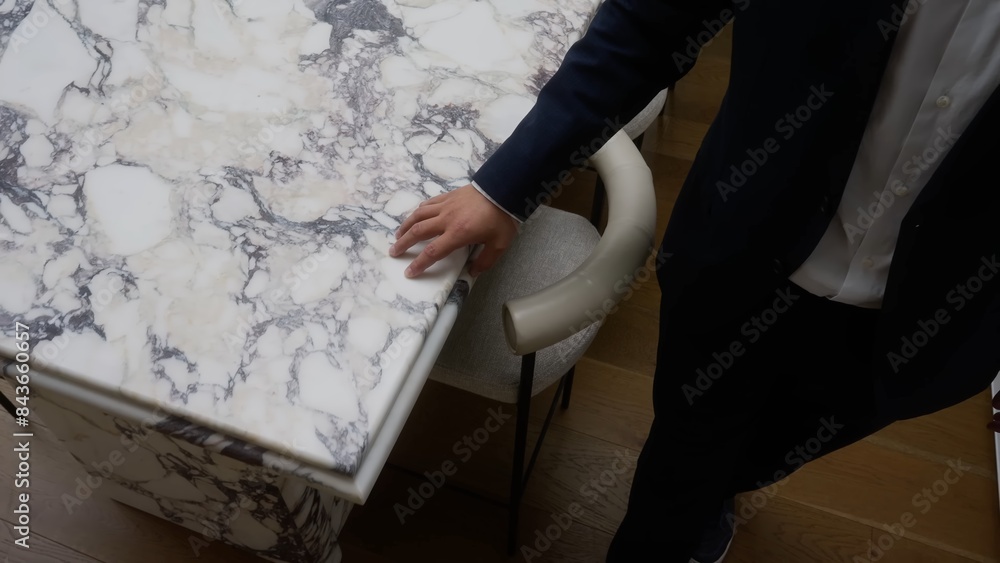 Tabletop made of white marble, a man's hand touches the table. Tabletop made of white marble, a man's hand touches the table.