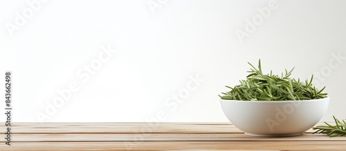 Bowl of dry tarragon on white wooden table Space for text. copy space available photo