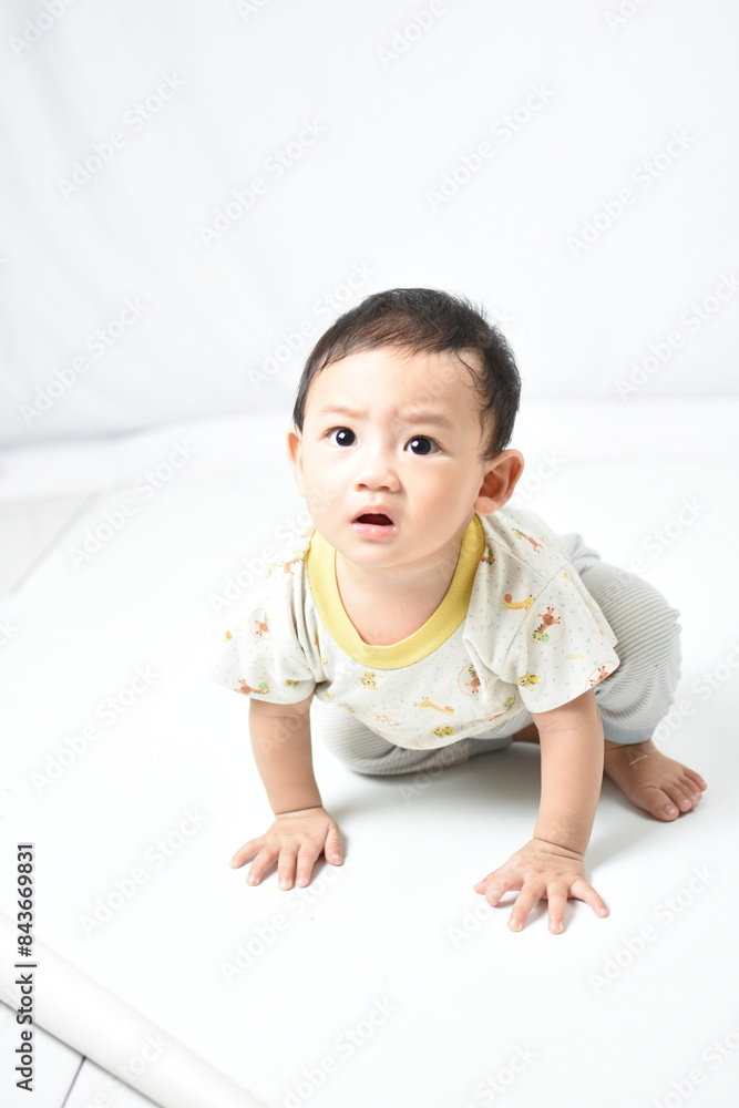 An inquisitive baby with wide eyes and a surprised expression, poised to crawl. Dressed in an adorable, animal-patterned outfit, the baby captures a moment of discovery and curiosity. An inquisitive baby with wide eyes and a surprised expression, poised to crawl. Dressed in an adorable, animal-patterned outfit, the baby captures a moment of discovery and curiosity.