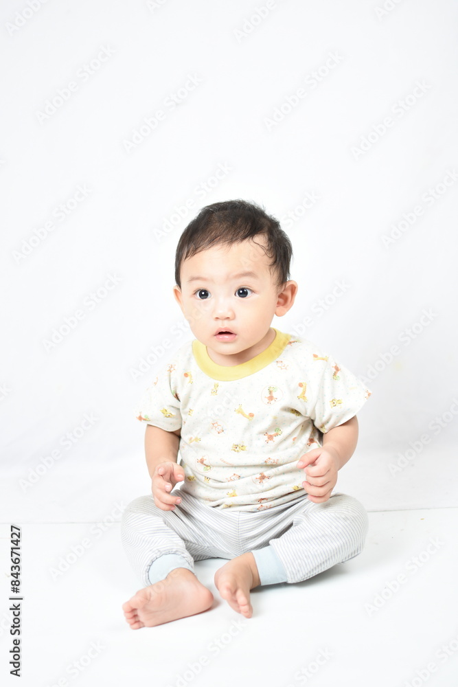 Cute baby Boy sitting on a white background,The baby has a curious and surprised expression, wide-eyed and mouth slightly open, capturing the innocence and wonder of early childhood. Cute baby Boy sitting on a white background,The baby has a curious and surprised expression, wide-eyed and mouth slightly open, capturing the innocence and wonder of early childhood.
