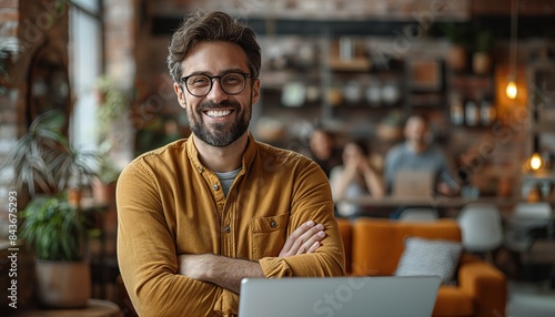 Man smiling and working on laptop in cafe