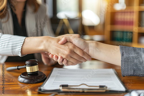 Female lawyer or notary shaking hands with a client in her office, representing legal services and agreements photo