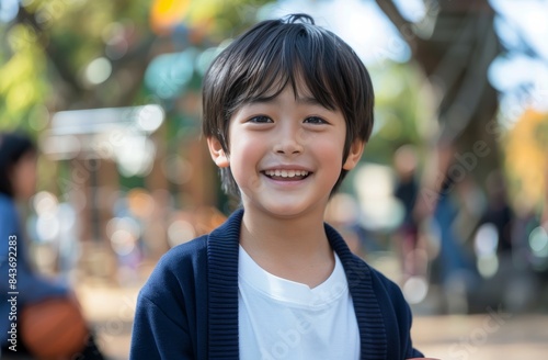 Young Boy Smiling While Holding Basketball in Park
