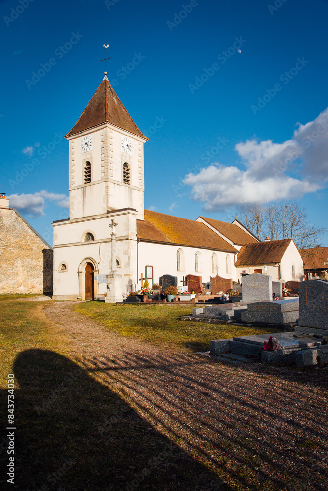 Naklejka premium Eglise et cimetière dans un village français. La religion chrétienne catholique en France. Eglise de campagne.