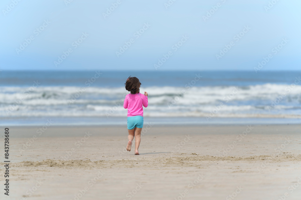 menina de 5 anos correndo sozinha na praia. Sensação de liberdade na infância. menina de 5 anos correndo sozinha na praia. Sensação de liberdade na infância.