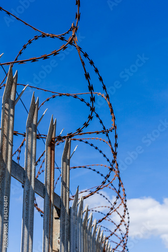 Rusty barbed wire on a metal fence