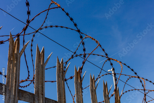 Rusty barbed wire on a metal fence